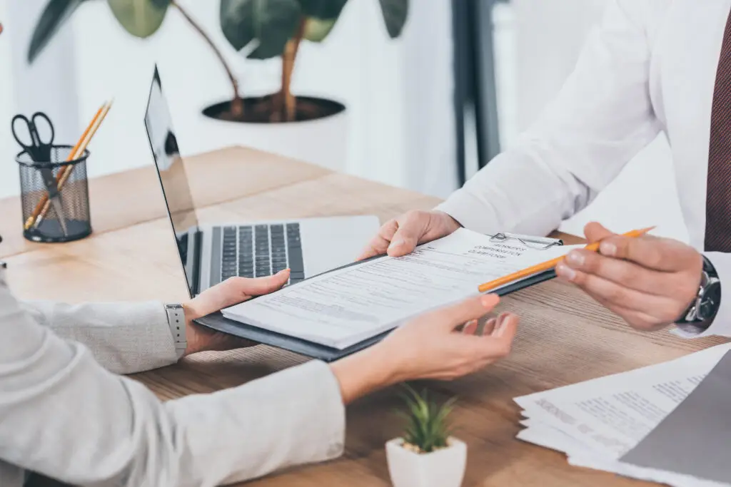 cropped view of businessman giving compensation claim form